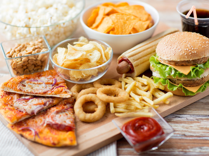 fast food and unhealthy eating concept - close up of fast food snacks and coca cola drink on wooden table